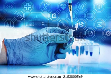 Scientist pipetting test tube in the Research Laboratory with data interface screen