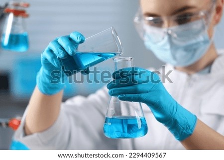 Scientist pouring sample into flask in laboratory, selective focus