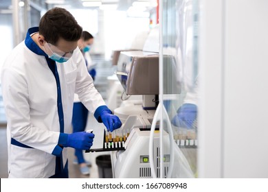 Scientist In Protective Medical Mask Doing Molecular Allergy Diagnostics In Laboratory Stock Photo