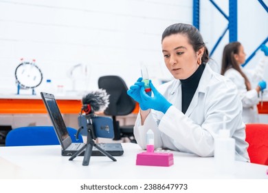 Scientist recording a video tutorial using phone sitting in a research laboratory