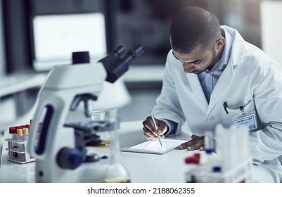 Scientist, Researcher And Medical Technician Writing On A Tablet, Recording Information And Results In A Lab. Focused And Serious Worker Using Technology For Innovation And Research In A Laboratory