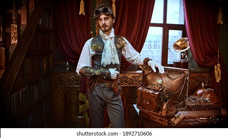 Scientist Steampunk Man Inventor Works In His Laboratory With Victorian Interior. Adventure World Of Steampunk.