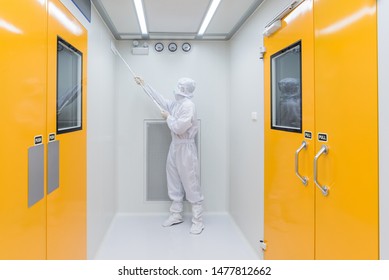 A Scientist In Sterile Coverall Gown Using Cleaning Tool For Cleaning Laboratory. Cleanroom Facility.