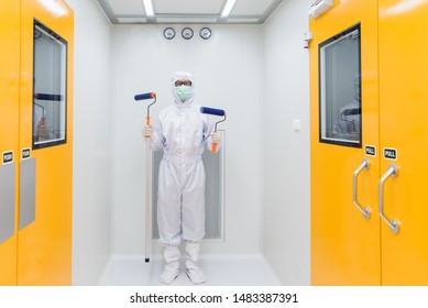 A Scientist In Sterile Coverall Gown Using Cleaning Tool For Cleaning Laboratory. Cleanroom Facility.
