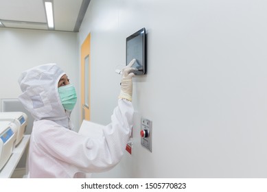 A Scientist In Sterile Coverall Gown Using A Daily Checklist Check The Cleanroom Condition Status In Laboratory. Cleanroom Facility.