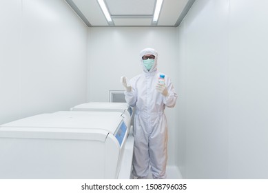 A Scientist In Sterile Coverall Gown Using Cleaning Tool For Cleaning Laboratory. Cleanroom Facility.