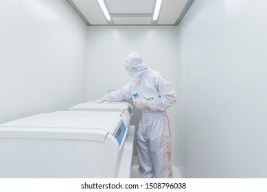 A Scientist In Sterile Coverall Gown Using Cleaning Tool For Cleaning Laboratory. Cleanroom Facility.