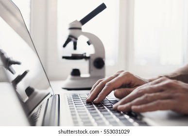 Scientist Or Student Using  Laptop Computer And Microscope. Science, Future, Forensic Laboratory, Research, Distance Education, Online Learning, Home Studying Concept