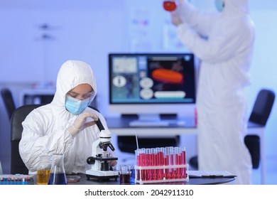 Scientist studying sample in laboratory - Shutterstock ID 2042911310