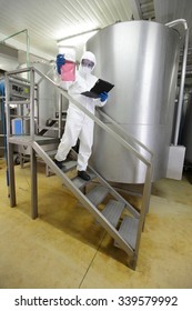 scientist with tablet checking sample in industrial interior