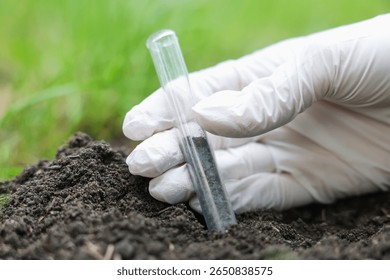 Scientist taking soil sample for research outdoors, closeup