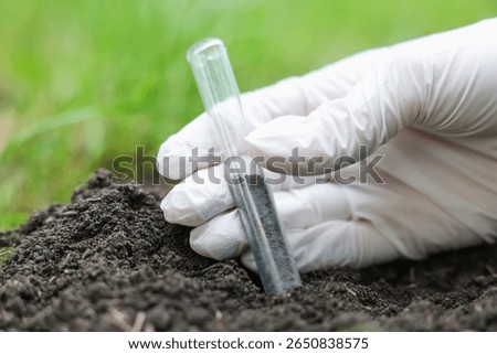 Scientist taking soil sample for research outdoors, closeup