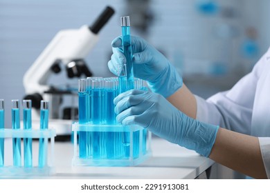 Scientist taking test tubes with samples from rack in laboratory, closeup - Powered by Shutterstock