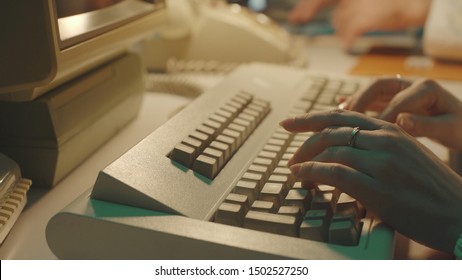 Scientist typing on a keyboard and using computer in a vintage lab, hands close up