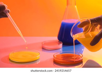 Scientist are using a beaker to pour chemical liquid into a petri dish and a pipette to drip liquid into another petri dish. Cosmetic beauty product production in laboratory concept - Powered by Shutterstock