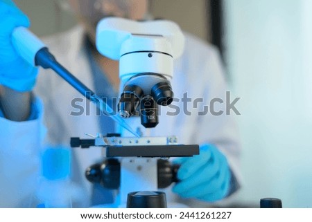A scientist is using a microscope to examine a sample. Concept of curiosity and scientific exploration