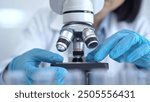 Scientist using microscope in laboratory. Close-up of a researcher