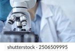 Scientist using microscope in laboratory. Close-up of a researcher