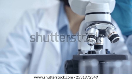 Scientist using microscope in laboratory. Close-up of a researcher's hands adjusting a modern microscope in a lab setting. Science concept