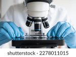 Scientist using microscope in laboratory, making medical testing and research, close-up