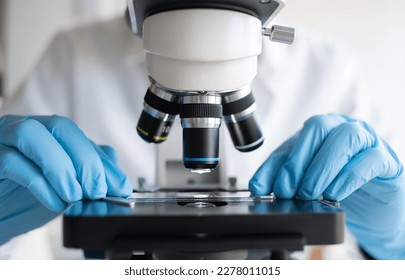 Científico que utiliza microscopio en laboratorio, realiza pruebas e investigaciones médicas, seguimiento