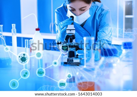 Scientist using modern microscope at table in laboratory. Researching of virus