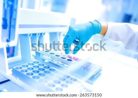 Scientist using protective robber gloves for handling dangerous substances and experiments
