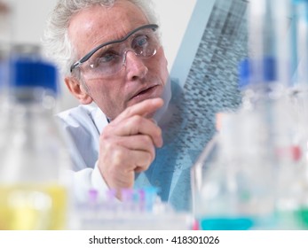 Scientist Viewing DNA Autoradiogram Experiment In Laboratory