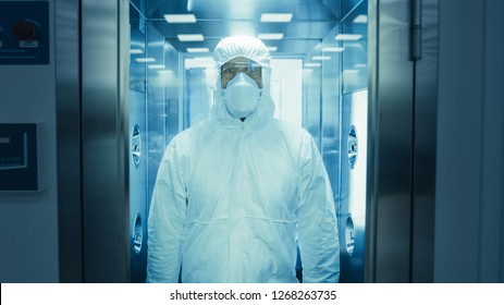 Scientist  Virologist  Factory Worker in Coverall Suit Disinfects Himself in Decontamination Shower Chamber. Biohazard Emergency Response.