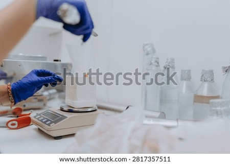 Scientist Weighing Tissue Sample On Laboratory Scale With Gloved Hands And Glass Reagents