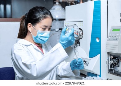 Scientist woman using micropipette for sample preparation with vial for Liquid Chromatography mass spectrometry LC-MS analysis in laboratory. LC-MS was used for pharmacology, chemistry, biotechnology.