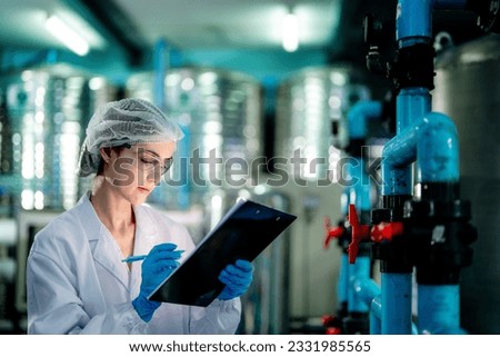 scientist worker checking the quality of Reverse osmosis machine system at the industrial factory. Female worker recording data at the control panel with measure pressure for recycle portable plant.