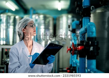scientist worker checking the quality of Reverse osmosis machine system at the industrial factory. Female worker recording data at the control panel with measure pressure for recycle portable plant.