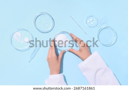 Scientist working with different samples in Petri dishes on blue background