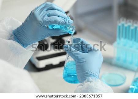 Scientist working with flasks in laboratory, closeup