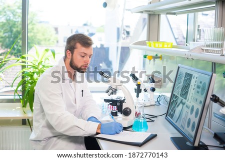 Scientist working in lab. Doctor making microbiology research. Laboratory tools: microscope, test tubes, equipment. Biotechnology, chemistry, bacteriology, virology, dna and health care.