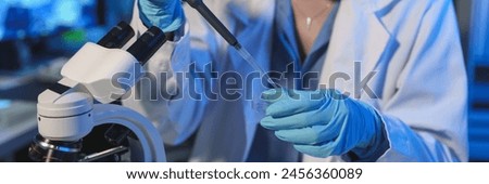 Scientist Working in the laboratory using a Micro Pipette. Mixing liquid chemicals with genetically modified samples under a microscope biotechnology, microbiology development, research experiments.