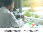 Scientist working with microscope in biology science laboratory