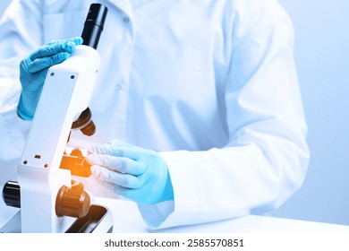 Scientist working with microscope in laboratory, closeup