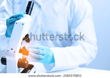 Scientist working with microscope in laboratory, closeup