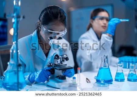 Scientist working with microscope and test tubes doing some research in a laboratory