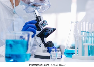 Scientist Working On Coronavirus Vaccine At Lab. 
Abstract Of Analyzing Covid 19 Sample With Microscope And Holding Coronavirus Covid 19 Blood Sample Tube In Laboratory.