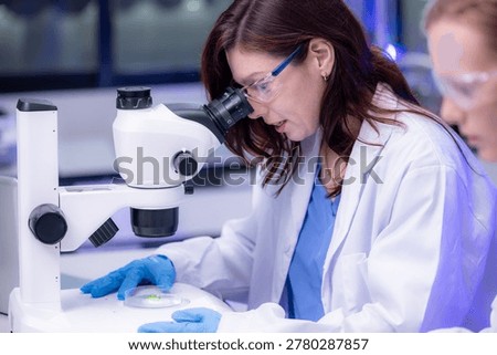 Scientist working with sample in laboratory, Scientific researcher in laboratory, Woman scientist examining sample using laboratory microscope, Caucasian female scientist microscope in modern lab.