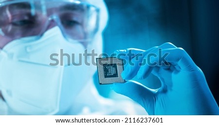 The scientist works in a modern scientific laboratory for the research and development of microelectronics and processors. Microprocessor manufacturing worker uses computer technology and equipment.