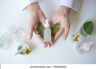 the scientist,dermatologist testing the organic natural  cosmetic product in the laboratory.research and development beauty skincare concept.blank package,bottle,container .cream,serum.hand