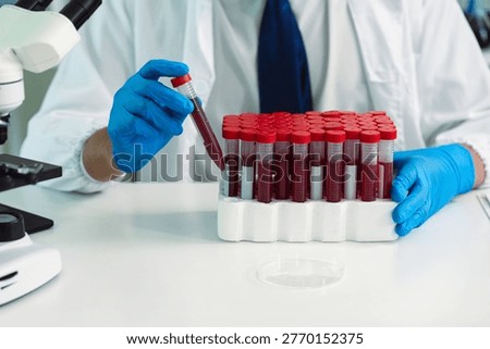 Scientists are analyzing blood samples in a laboratory related to medical research and development, blood analysis, and biotechnology.