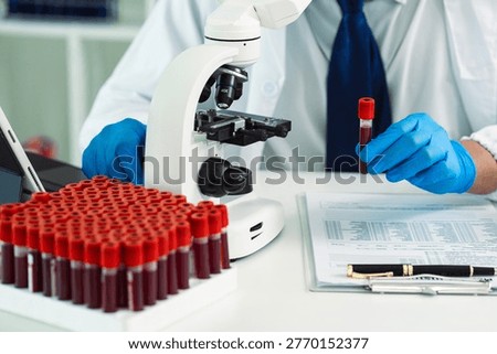 Scientists are analyzing blood samples in a laboratory related to medical research and development, blood analysis, and biotechnology.