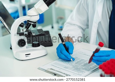 Scientists are analyzing blood samples in a laboratory related to medical research and development, blood analysis, and biotechnology.