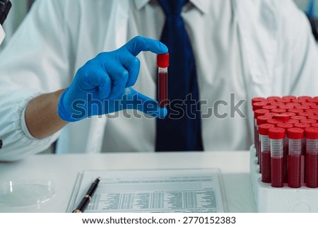 Scientists are analyzing blood samples in a laboratory related to medical research and development, blood analysis, and biotechnology.