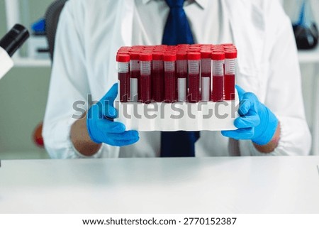 Scientists are analyzing blood samples in a laboratory related to medical research and development, blood analysis, and biotechnology.
